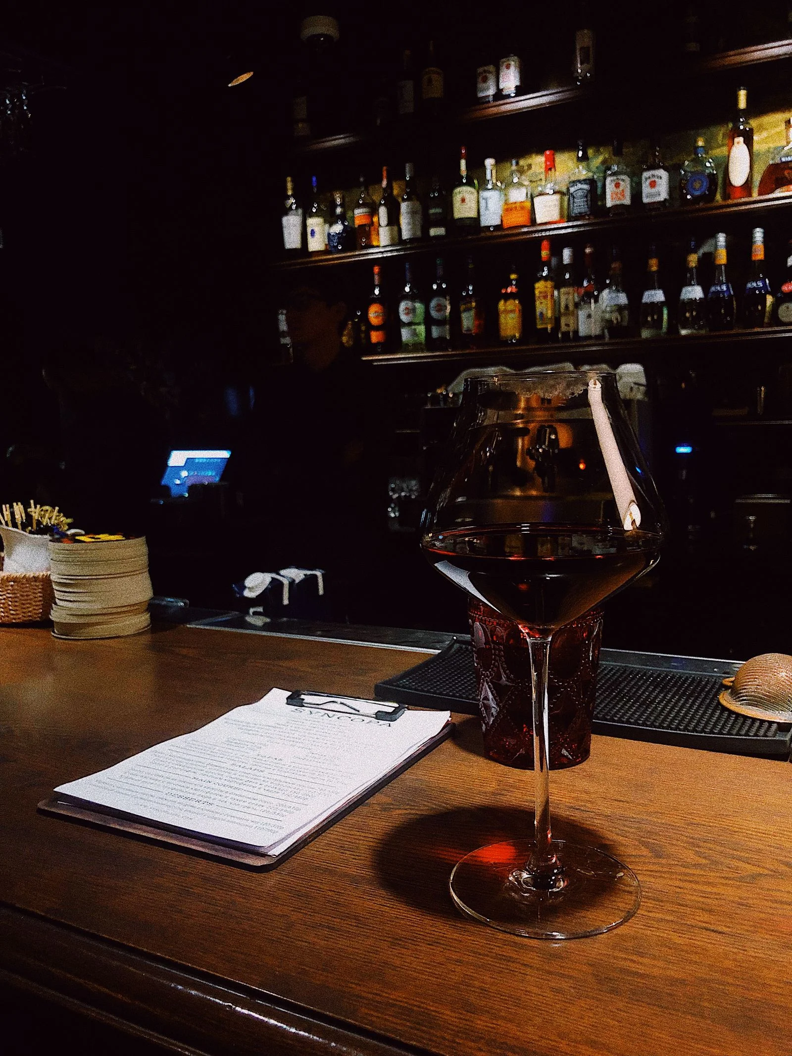 A glass of red wine at a softly lit bar